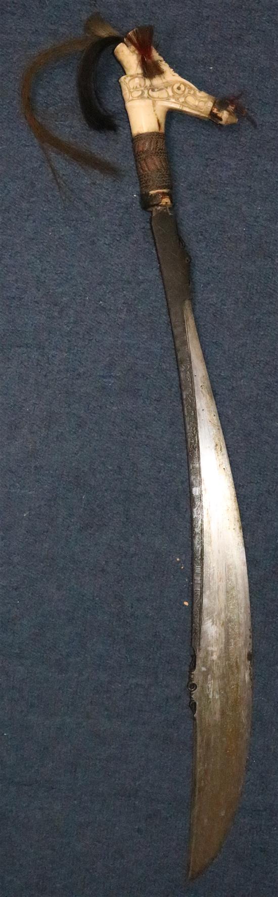 A Dayak stag horn-handled Mandau (head-hunters sword), wood scabbard, late 19th / early 20th century, total length 78.5cm (30.9in.)